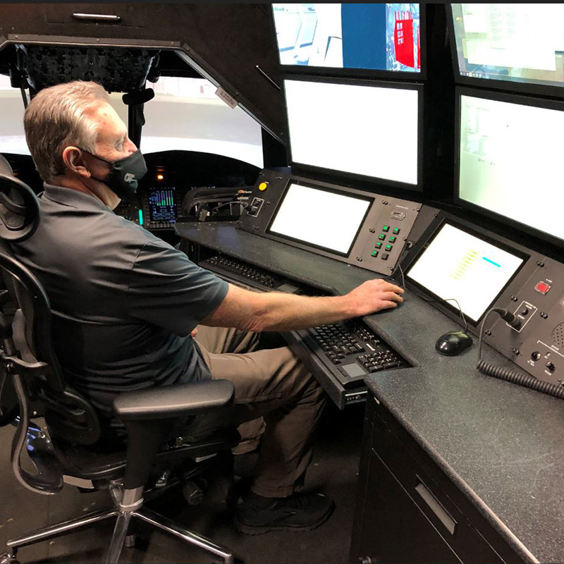 A man sitting at the control desk of an aircraft.